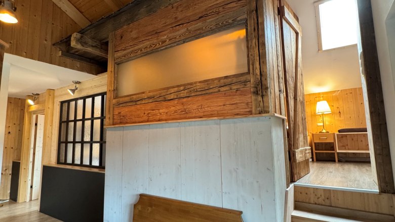 Famiienzimmer- Kräuterhäusl Puchenstuben, © Kräuterhäusl Puchenstuben Familienzimmer mit Holzwänden, Holzboden und einer Holzbank. Eine Treppe führt zu einem höher gelegenen Raum.