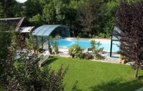 die-gartenlaube, © Staudinger Ein Garten mit Pool und Überdachung, umgeben von Bäumen und Rasen.