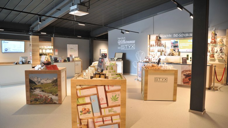 STYX Welcome Center- Shop, © Styx Naturkosmetic GmbH Innenansicht des Styx Welcome Centers mit Kosmetik- und Schokoladenprodukten.