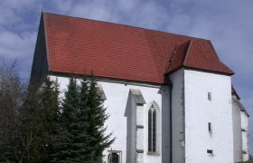 Andreaskirche Kirchberg an der Pielach, © Gerhard Hackner Andreaskirche in Kirchberg an der Pielach mit rotem Ziegeldach und weißer Fassade, umgeben von Bäumen und einem Weg im Vordergrund.