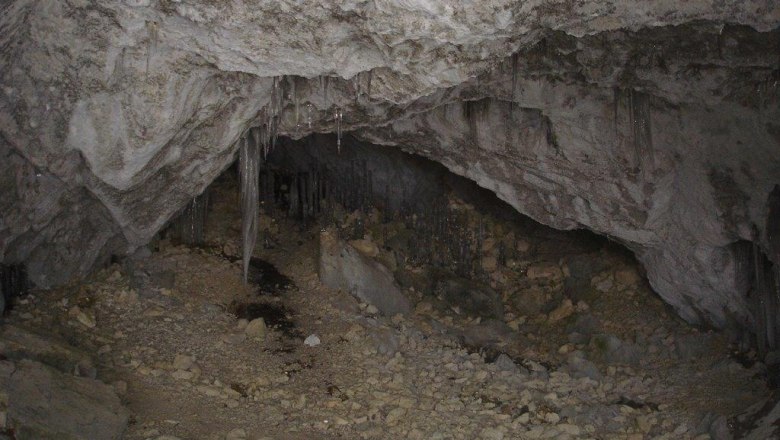 Trockene Höhle, © Schwarzenbach/Piel. Innenansicht einer trockenen Höhle mit Stalaktiten und steinigem Boden.