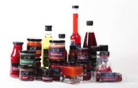 Dirndl Haus, © zVg Dirndl Haus Verschiedene Produkte des Dirndl Haus, darunter Honig, Gelee, Senf und Öl, auf weißem Hintergrund.