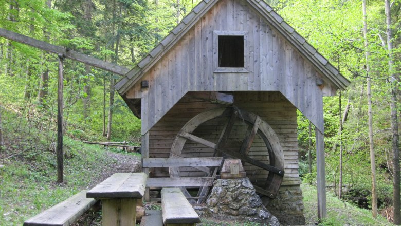Holzmühle mit Wasserrad im Wald