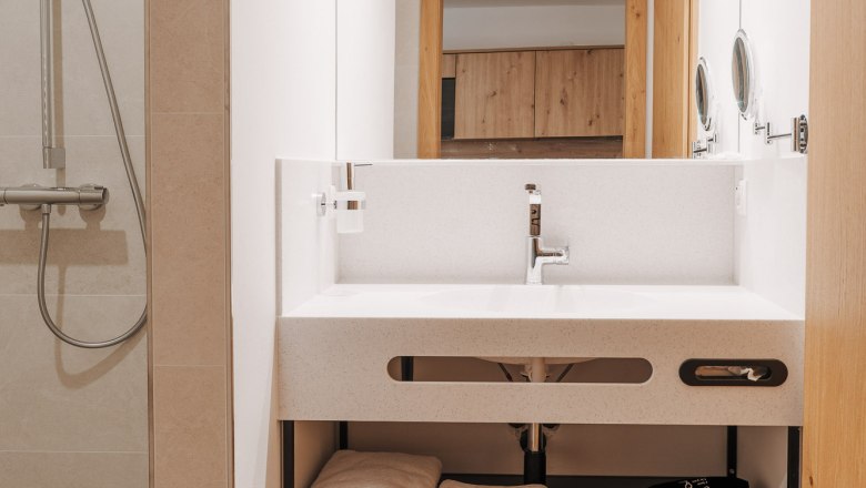 Modernes Badezimmer mit Waschbecken, Spiegel und Dusche.