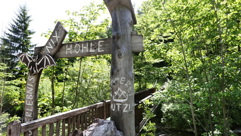 Eingang zur Nixhöhle bei Frankenfels mit Holzschild und Fledermaus-Dekoration.