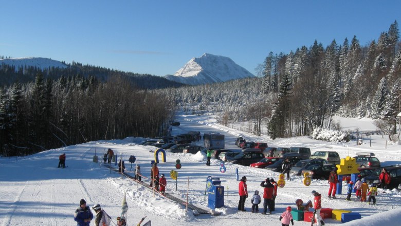 Winterlandschaft mit Skilift und spielenden Kindern in Puchenstuben.