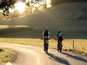 Zwei Radfahrende am Pielachtalradweg bei heller Lichtstimmung.