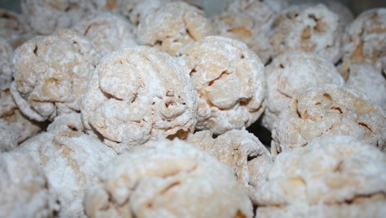 Nahaufnahme von mit Puderzucker bestäubten Gebäckkugeln.