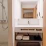 Modernes Badezimmer mit Waschbecken, Spiegel und Dusche.