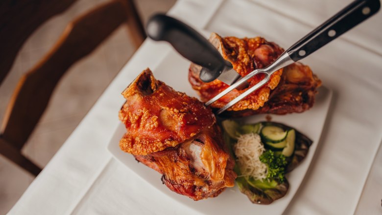 Zwei Schweinshaxen auf einem Teller mit Beilagen.