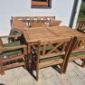 Holz-Gartenm&ouml;bel-Set mit Tisch, St&uuml;hlen und Bank auf einer Terrasse.