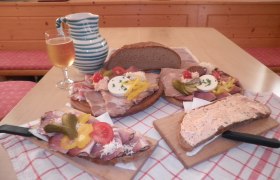 Traditionelle österreichische Jause mit Brot, Aufschnitt und Getränk.