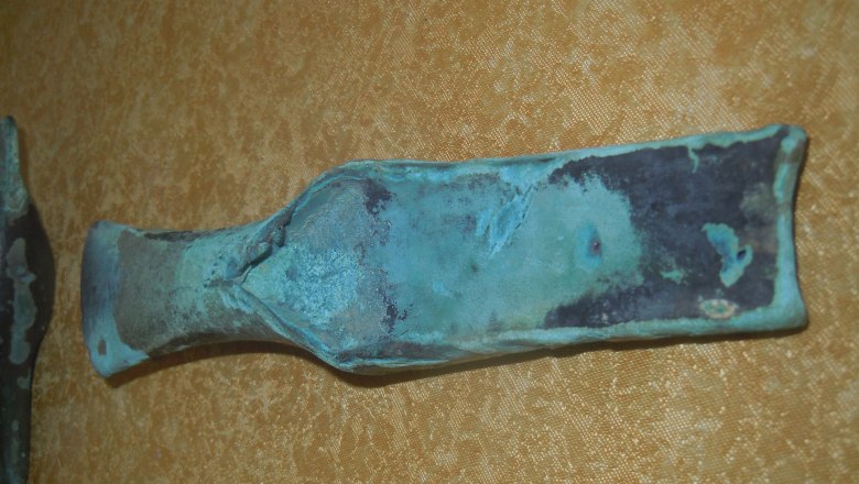 Ein altes, oxidiertes Metallwerkzeug auf gelbem Hintergrund.