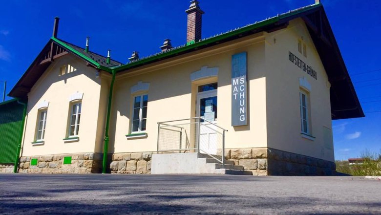 Au&szlig;enansicht eines kleinen Museumsgeb&auml;udes mit gelber Fassade und gr&uuml;nen Akzenten.